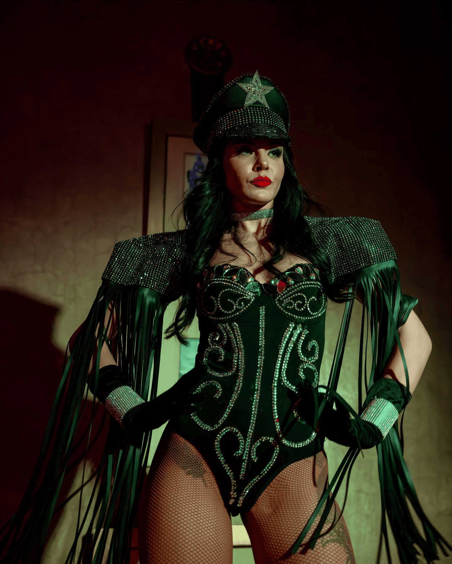 Artiste du spectacle posant dans un costume militaire de luxe à paillettes et casquette