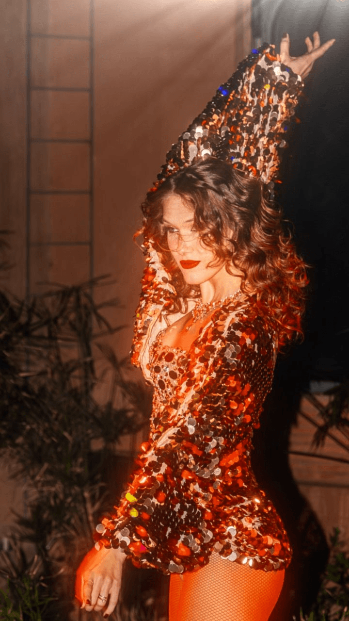 Artiste danseuse en costume à paillettes rouges et or posant pendant le show