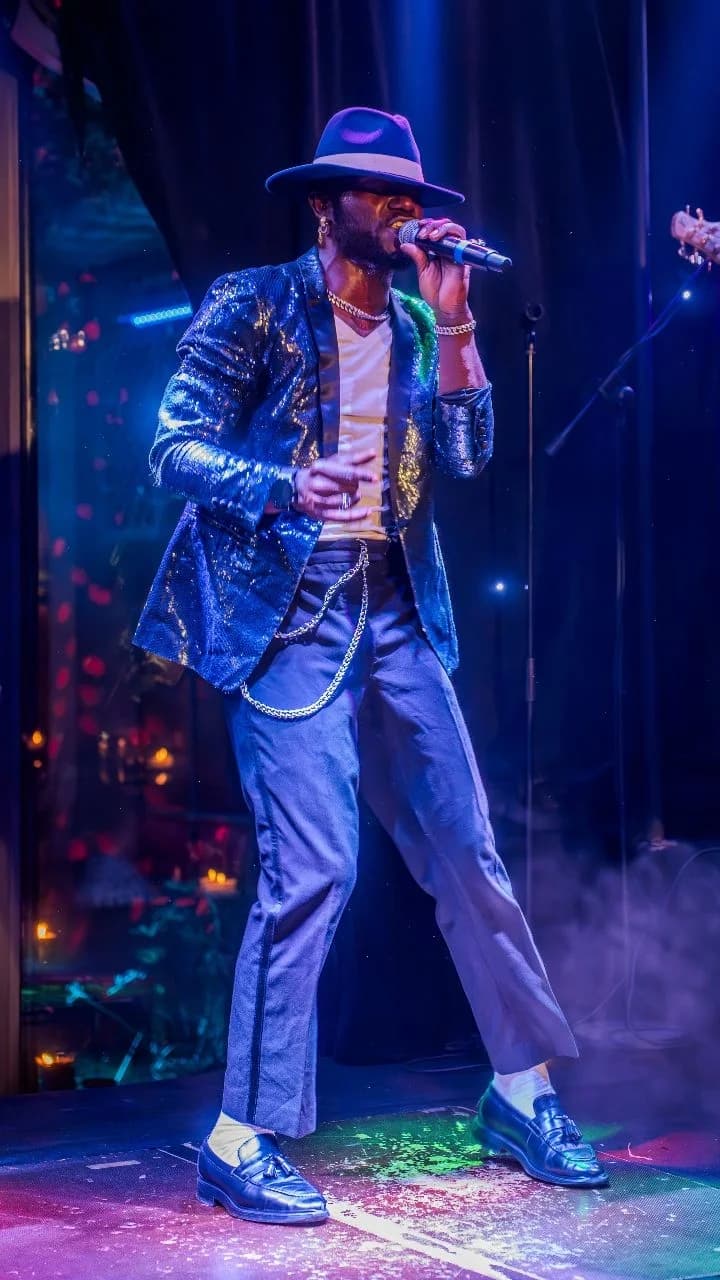 Chanteur du live band en costume pailleté chantant sur scène au Palais Jad Mahal